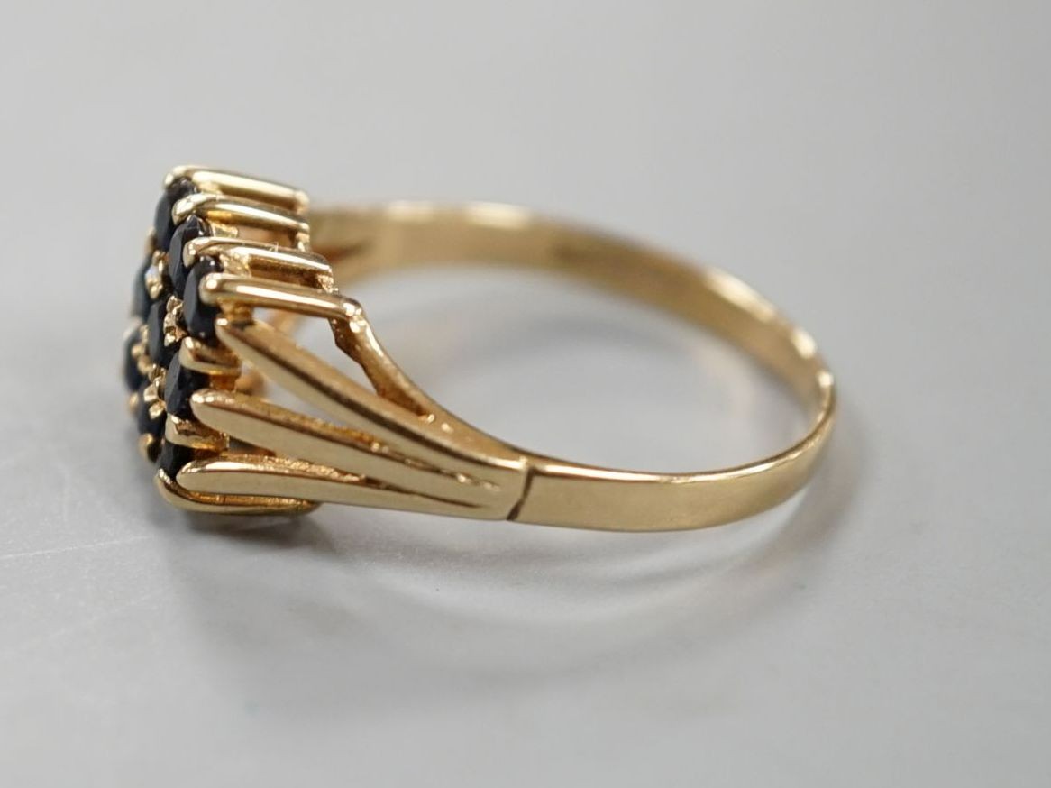 A modern 9ct gold and nine stone sapphire set tablet ring, size R/S, gross weight 2.7 grams.